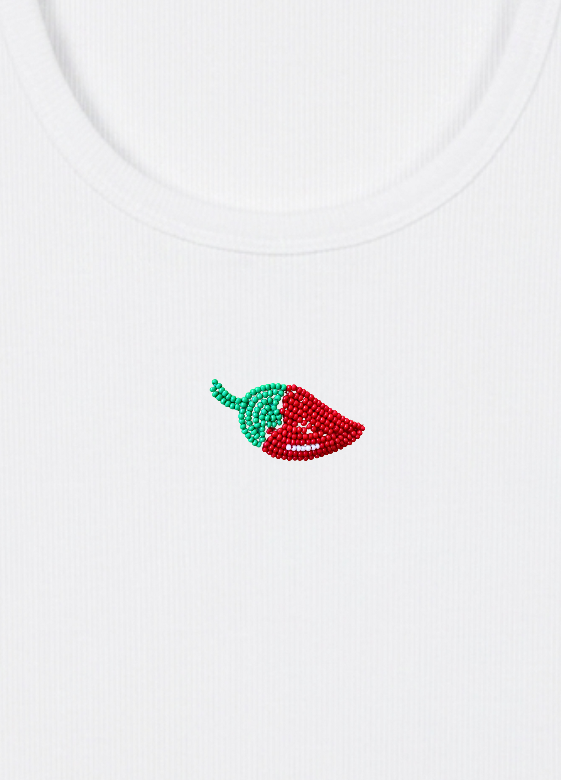 White tank top with a red and green chili pepper design on a light yellow background